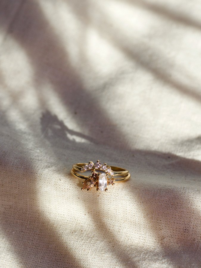 sapphire and morganite champagne-colored cluster ring paired with a curved diamond wedding band