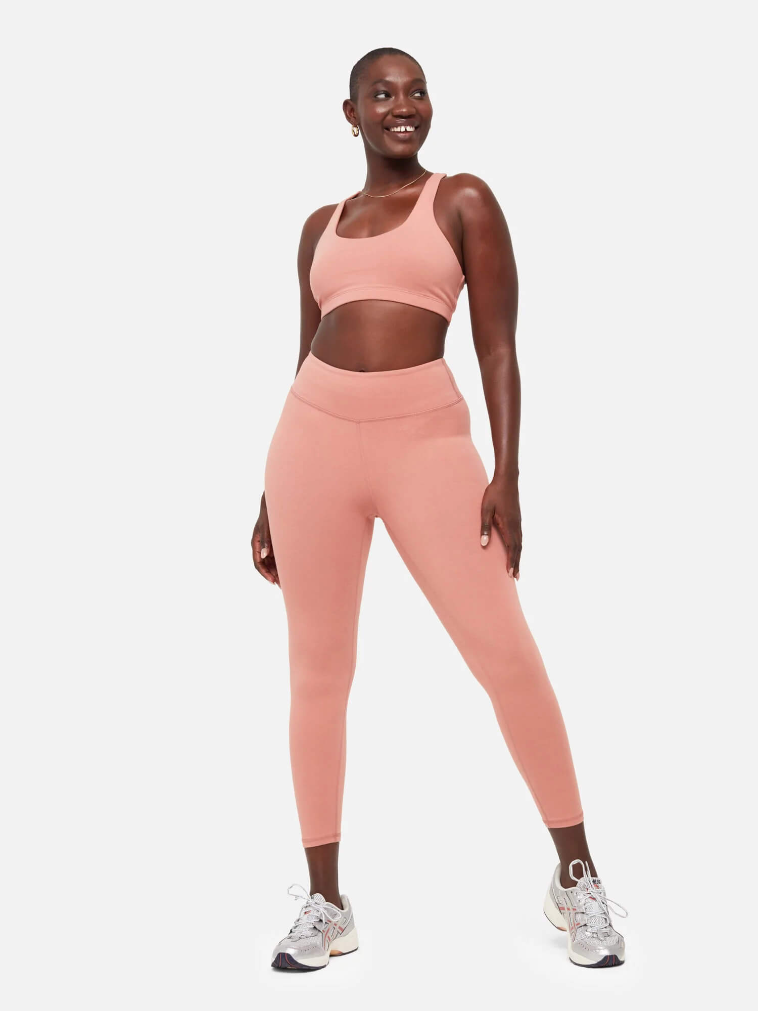 A model wears a coral cotton legging and bra set.