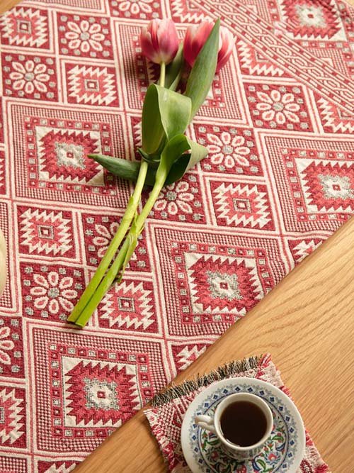 Tablecloths & Runners: Oddbird's Waste-Not-Want-Not Ottoman Table Runner made from repurposed ottoman fabric, in a deep crimson and white pattern. There are 2 tulips resting on the runner on top of a wodden table, next to coffee on a matching coaster