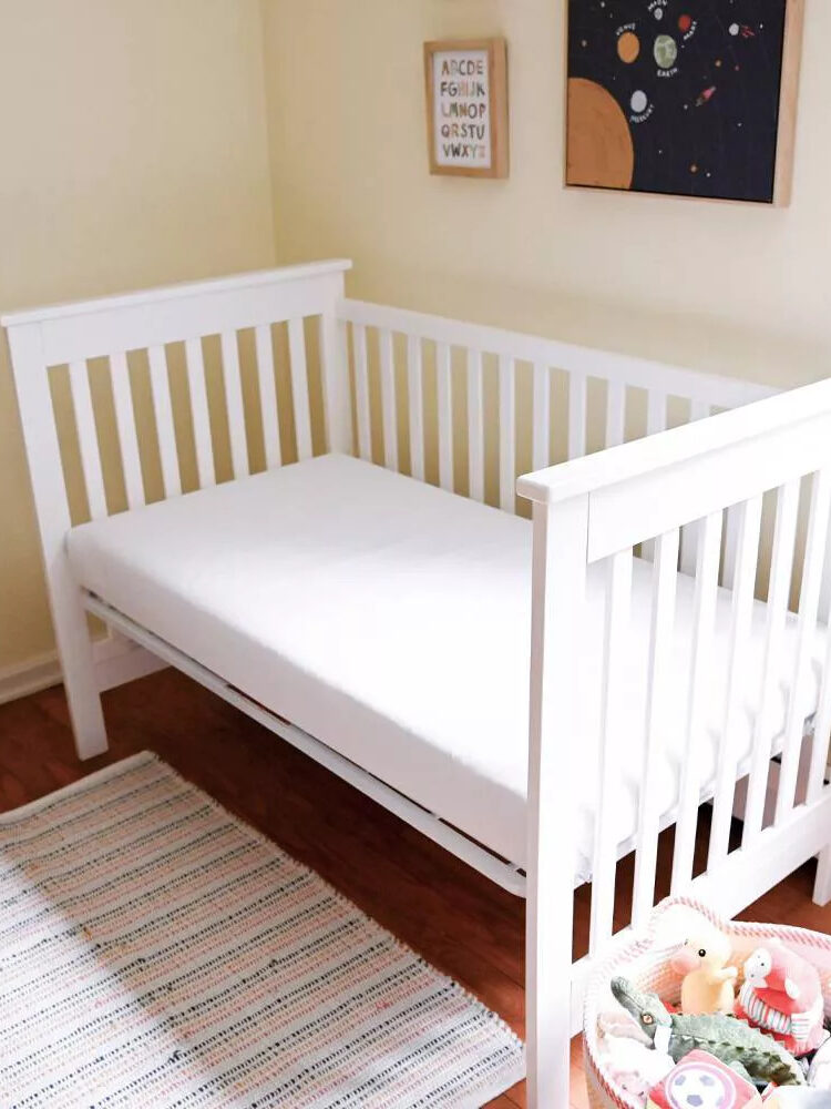 A white Lullaby Earth crib and mattress