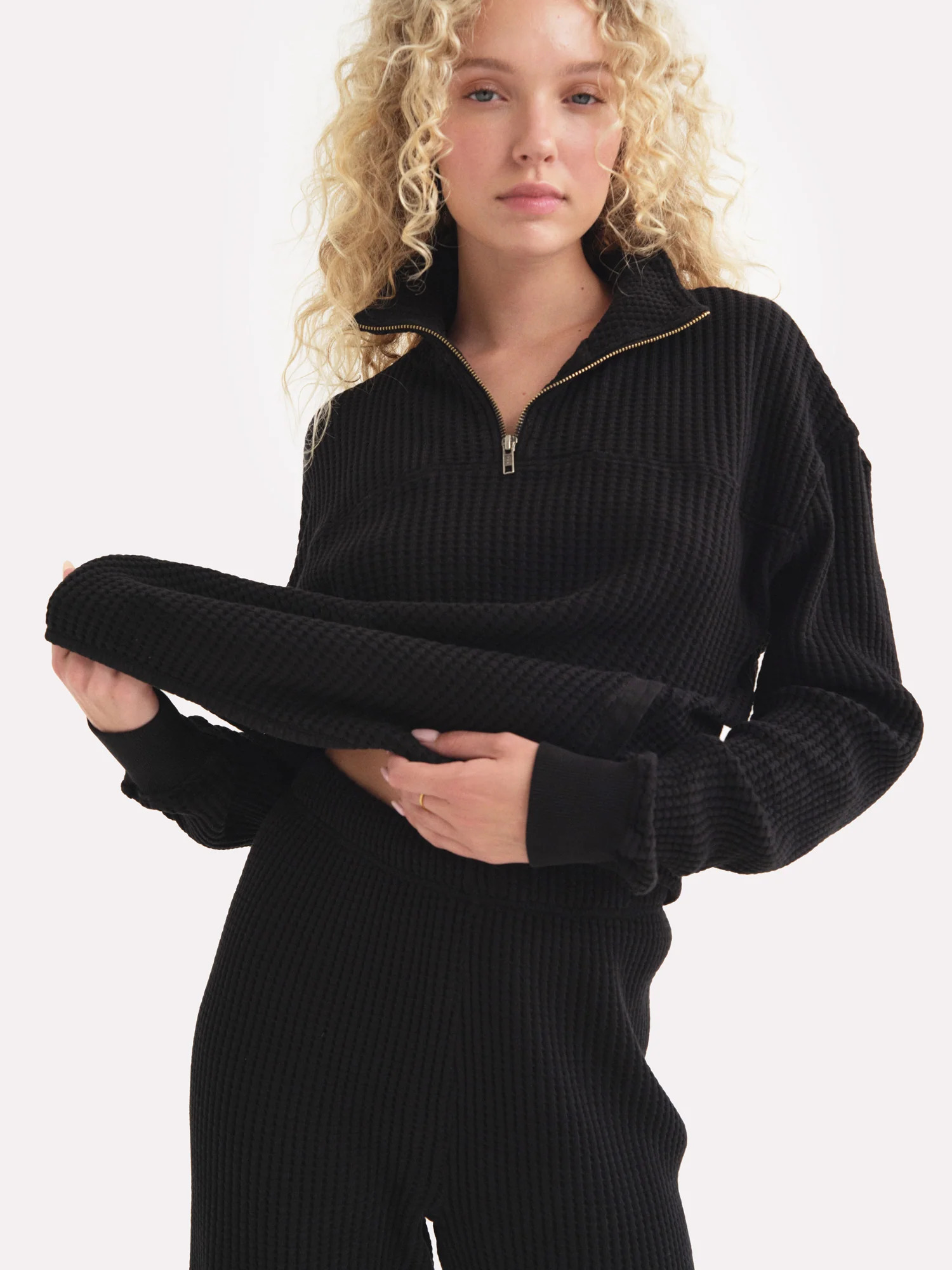 A model wearing a black MATE The Label sweat set.