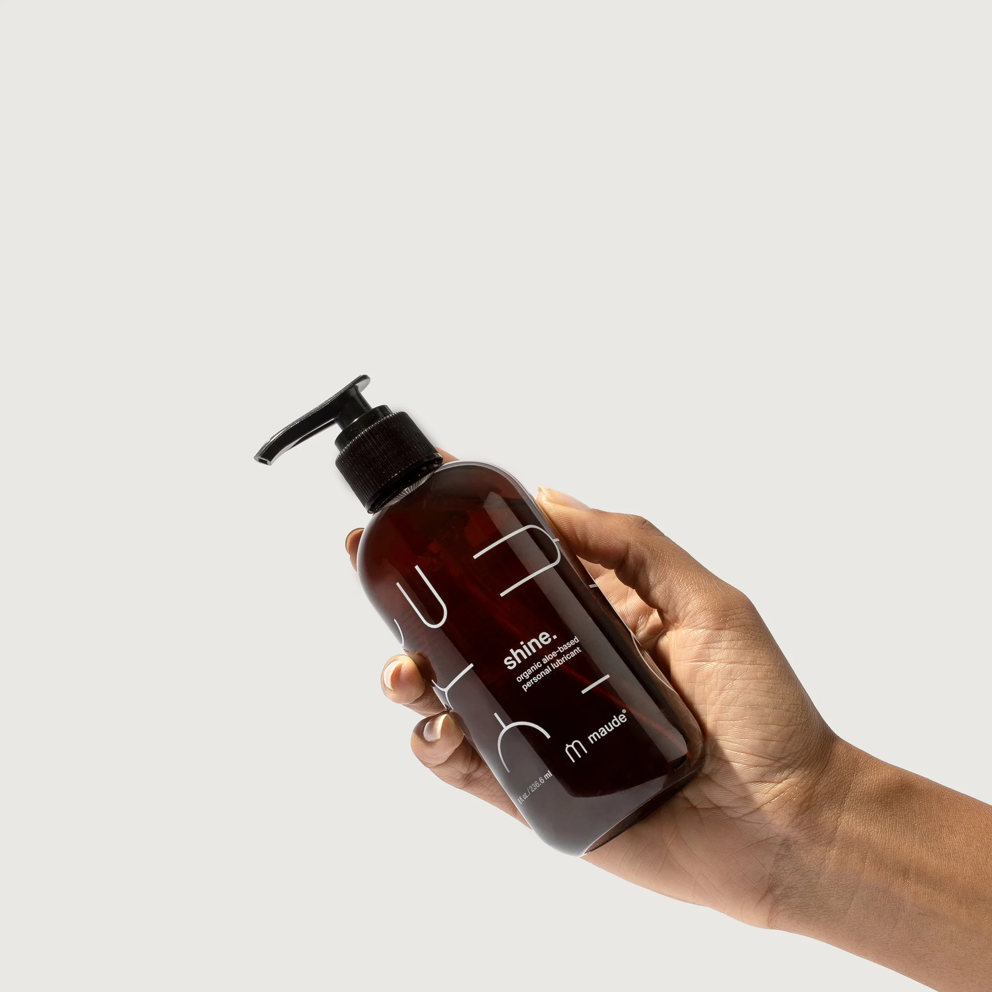 A hand holding Maude lubricant