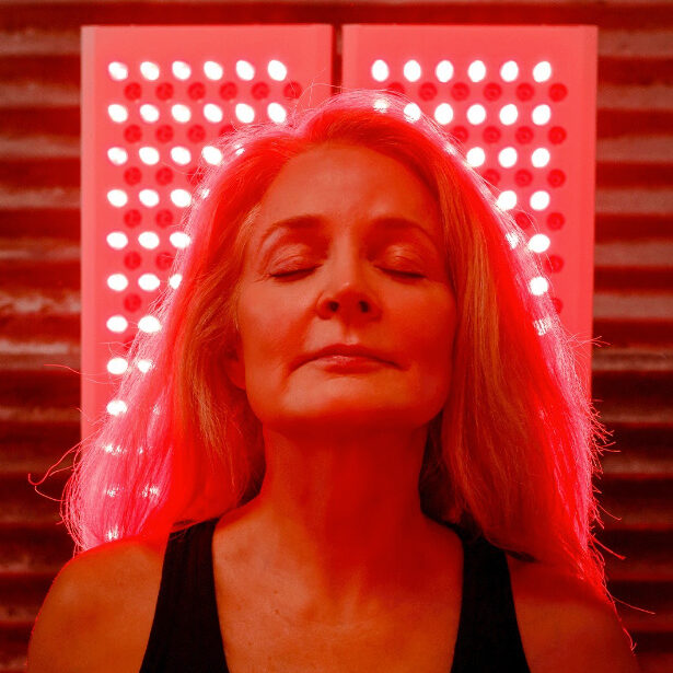 A model sits in a red light walled room.