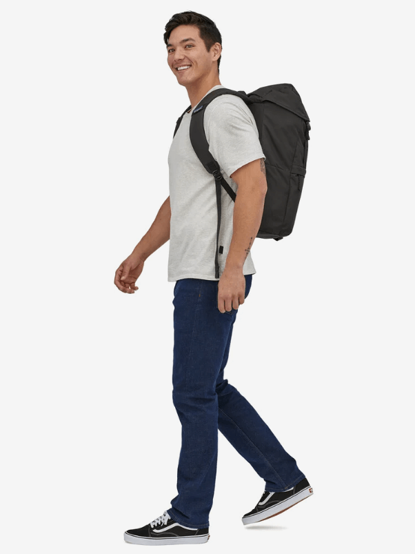 A model walks by with a backpack on. 