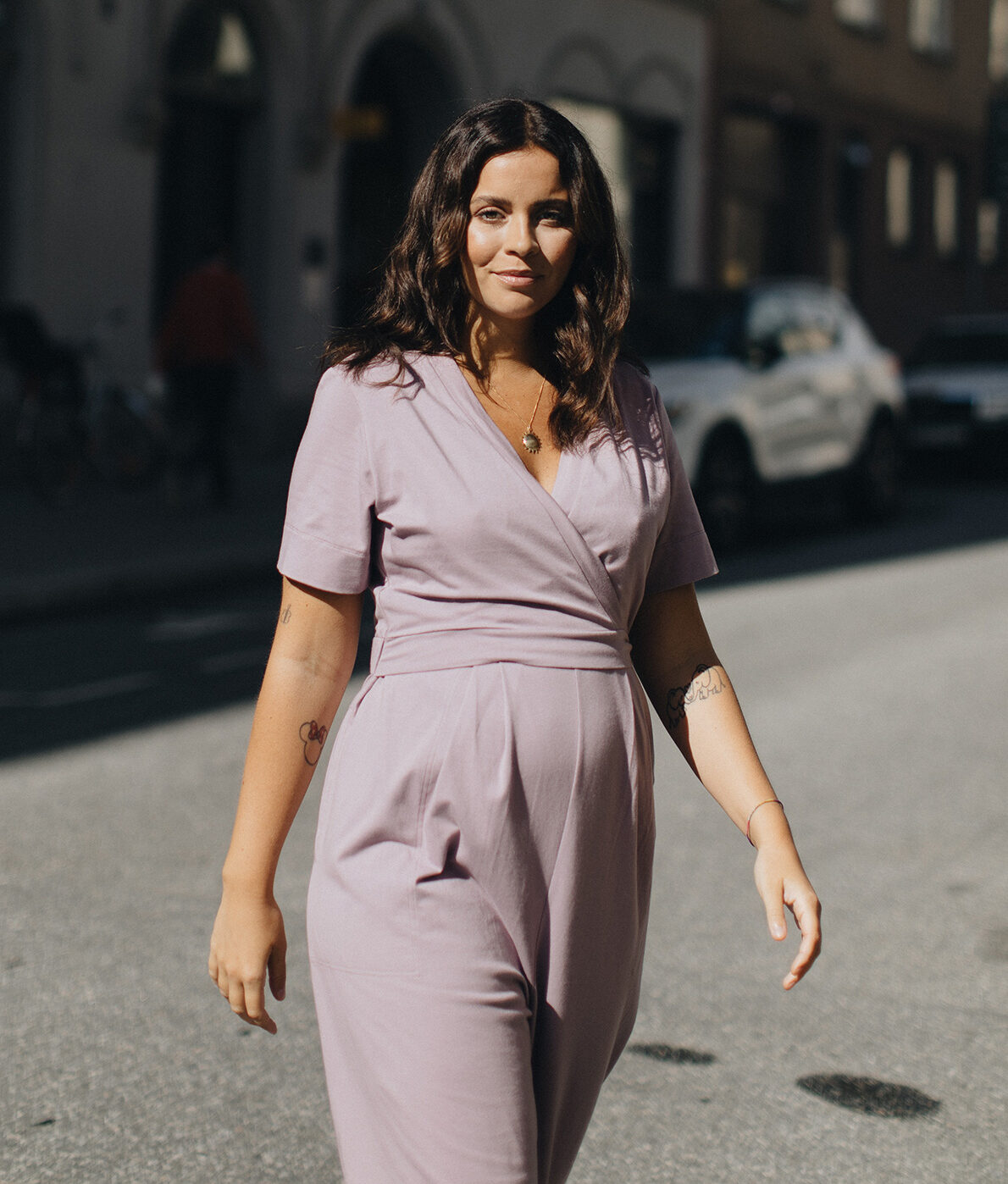 A pregnant model in a lilac jumpsuit.