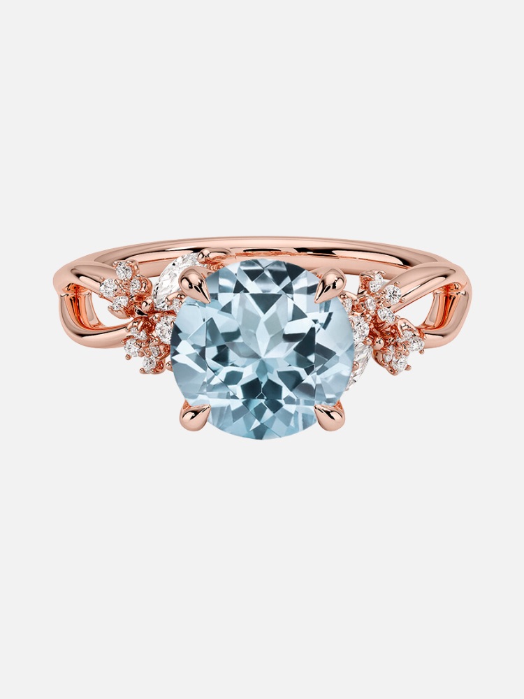 A rose gold ring with a central blue gemstone flanked by diamond accents.