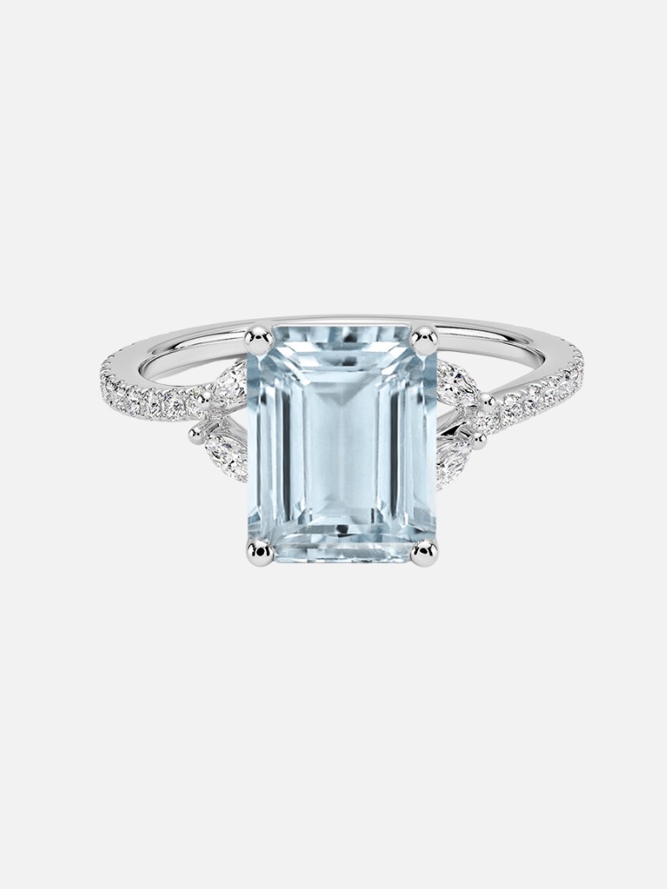 A silver-toned ring with a large emerald-cut center stone and smaller round diamonds on the band.