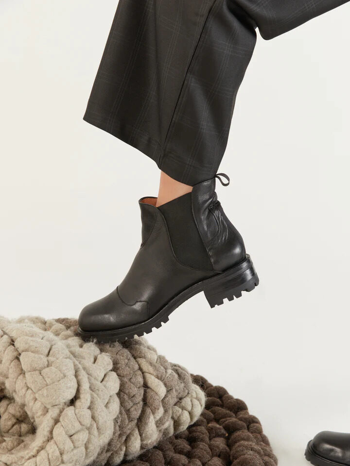 A model wearing black Zou Xou sustainable winter lug boots.