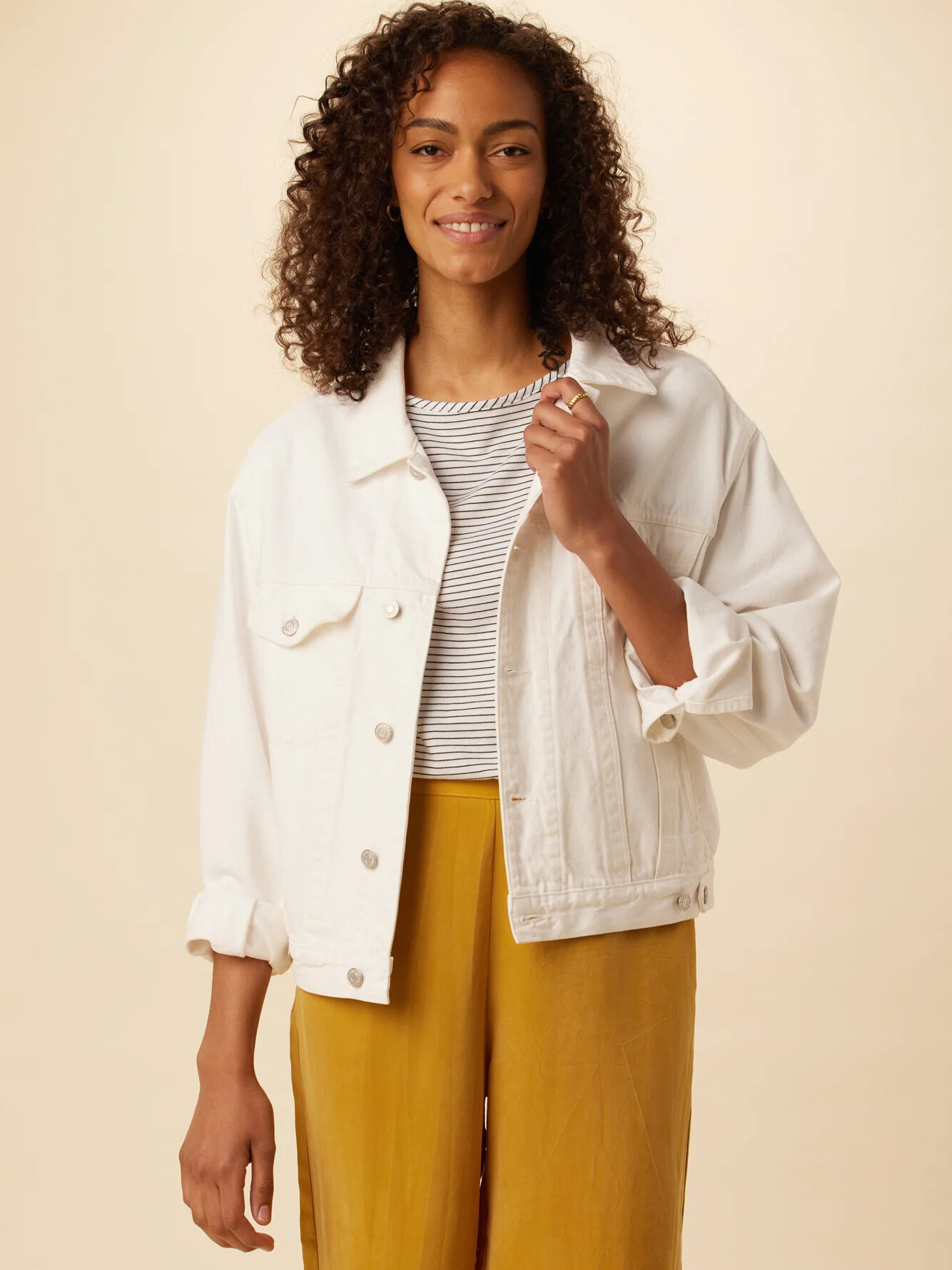 Model wearing AGOLDE White Denim Jacket with a grey shirt underneath and yellow wide leg pants