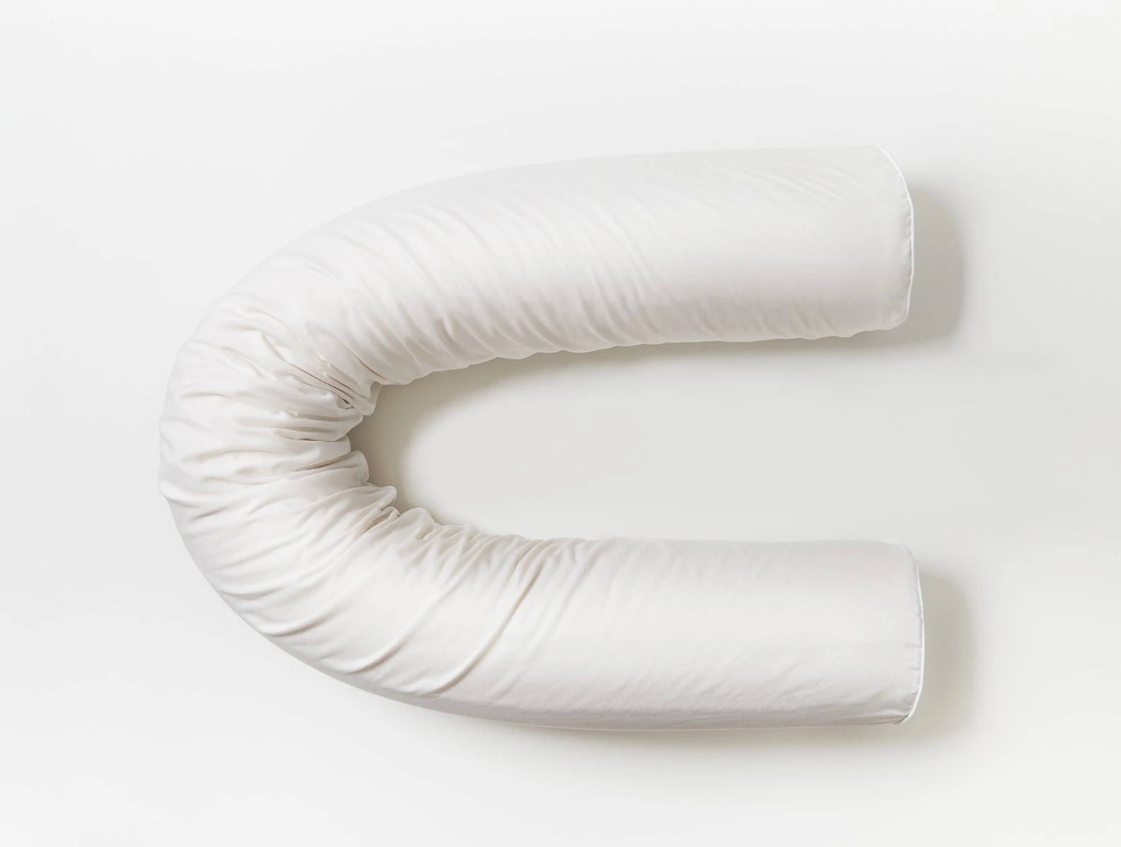The Coyuchi body pillow in a U-shape.