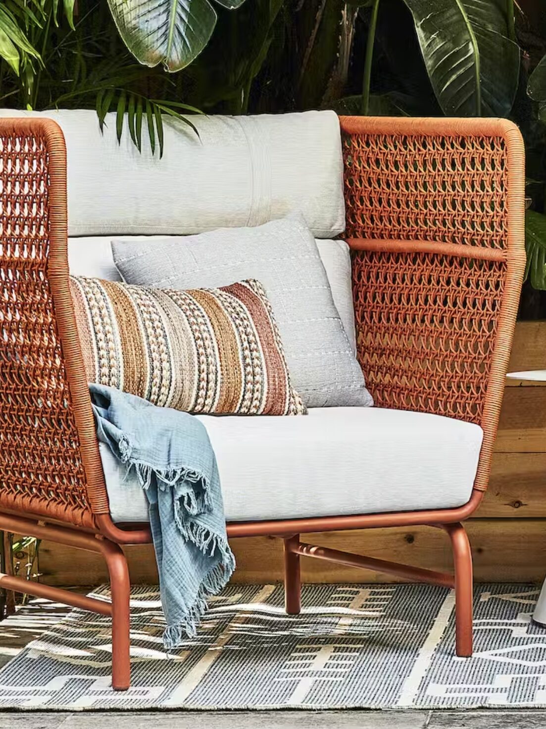A woven outdoor chair with cushions