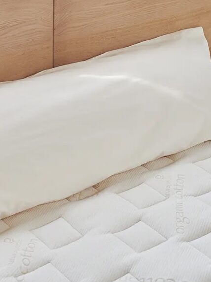 A body pillow on a mattress.