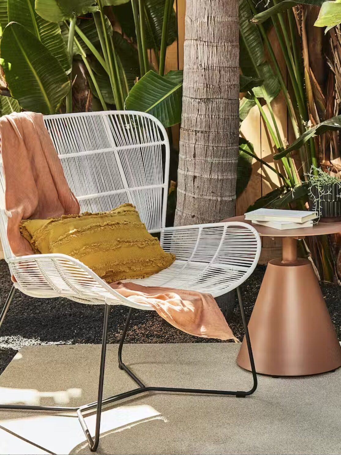 A white outdoor chair and metal side table