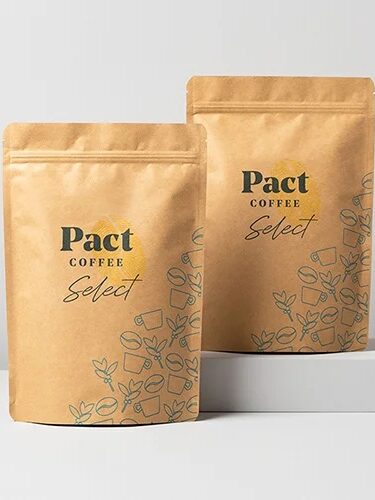 Two bags of Pact coffee stand on gray platforms