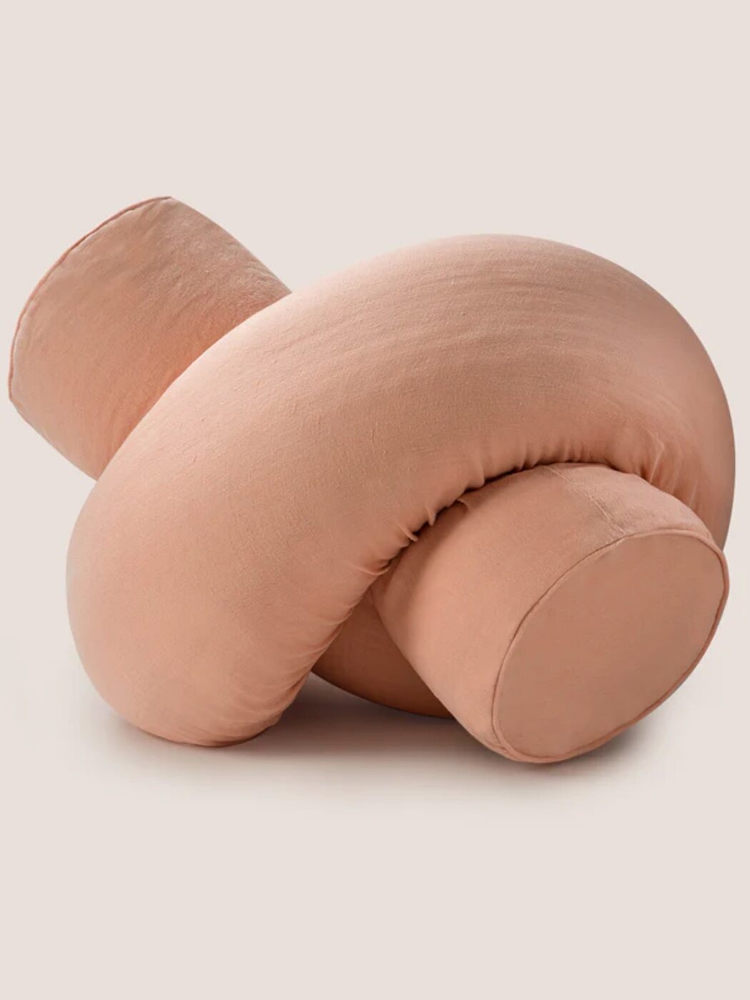 The Bearaby pillow in a pink cover tied into a knot.