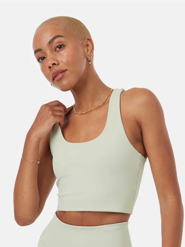 Model in light green sports bra and leggings