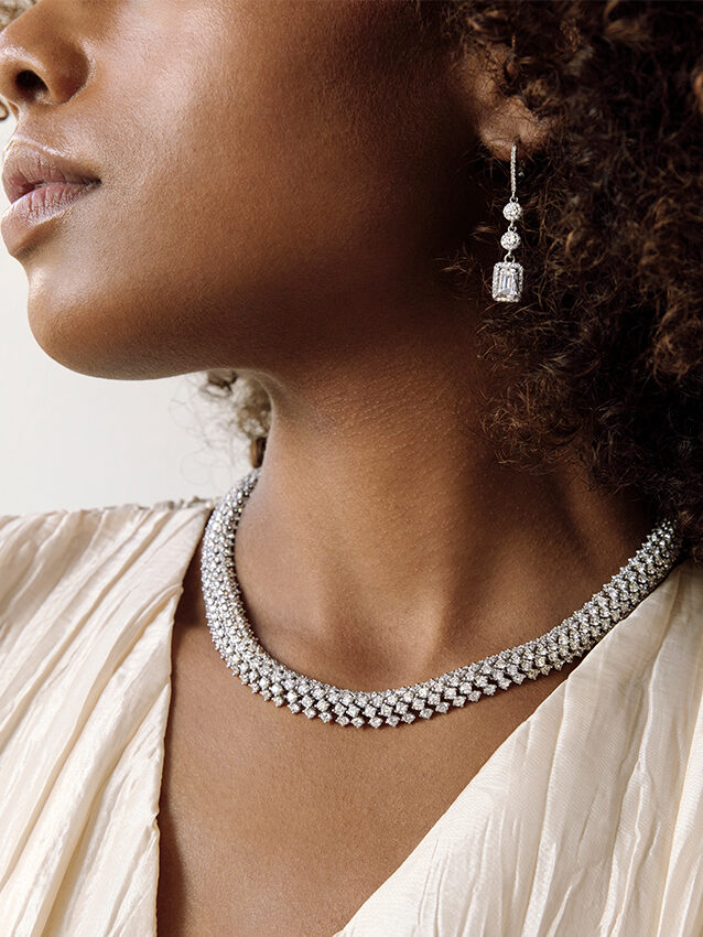 A model wears a diamond necklace and diamond earrings