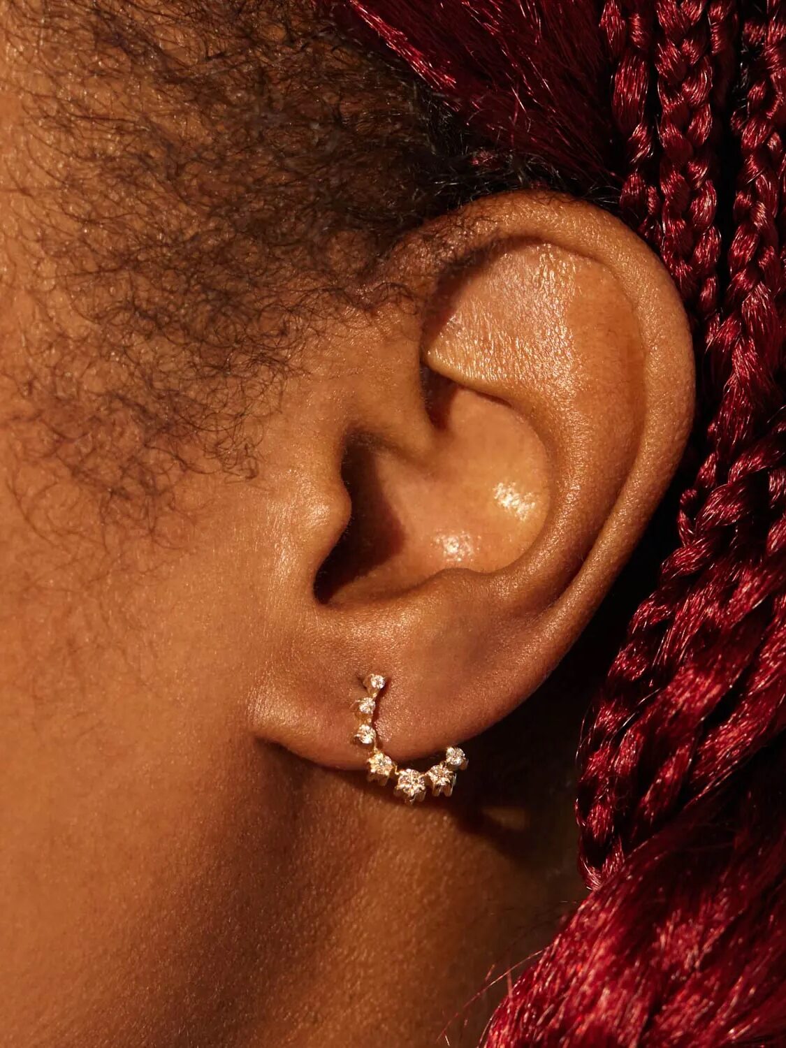A diamond earring in an ear.