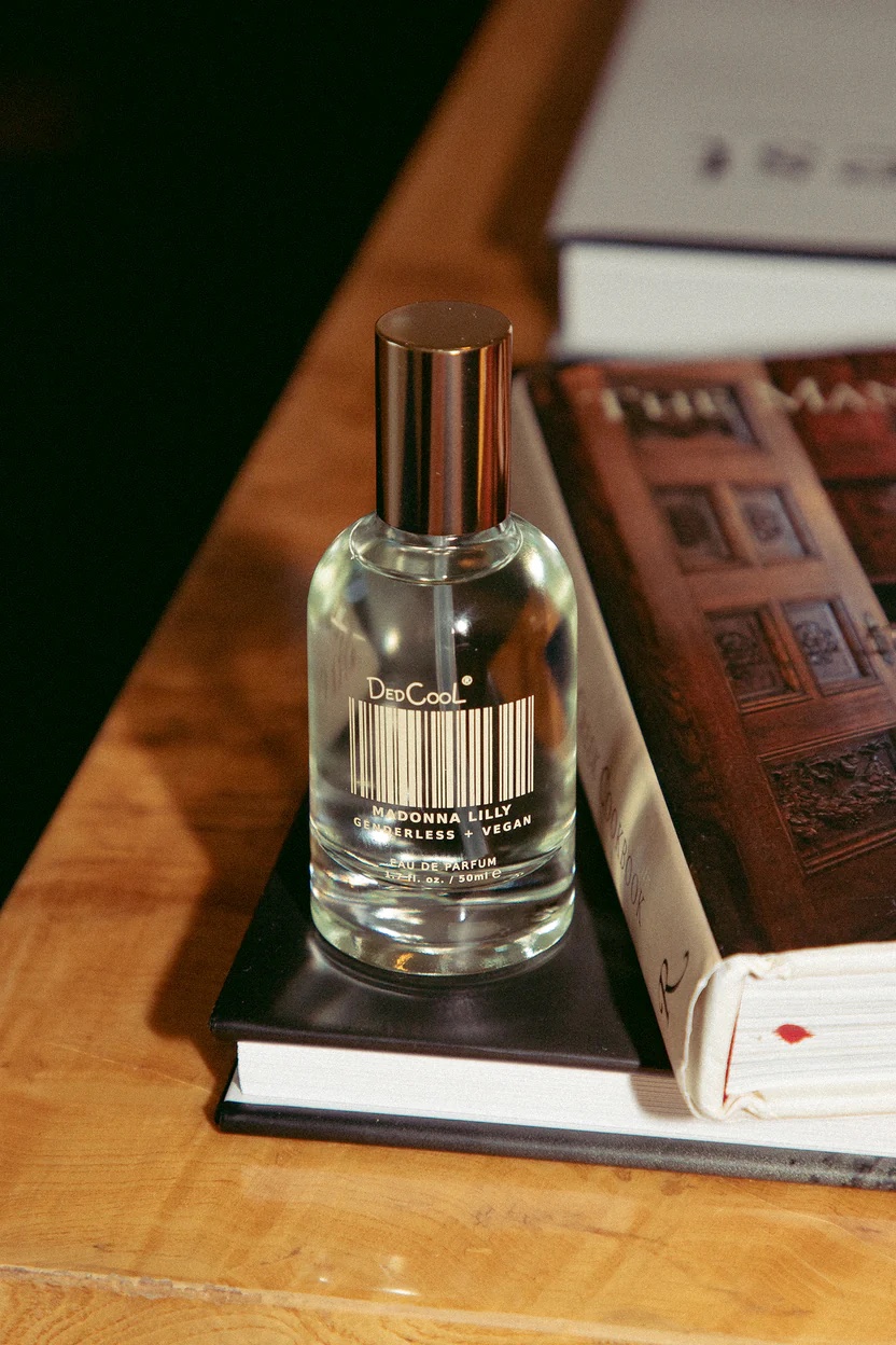 A bottle of personal fragrance sits on a stack of books.