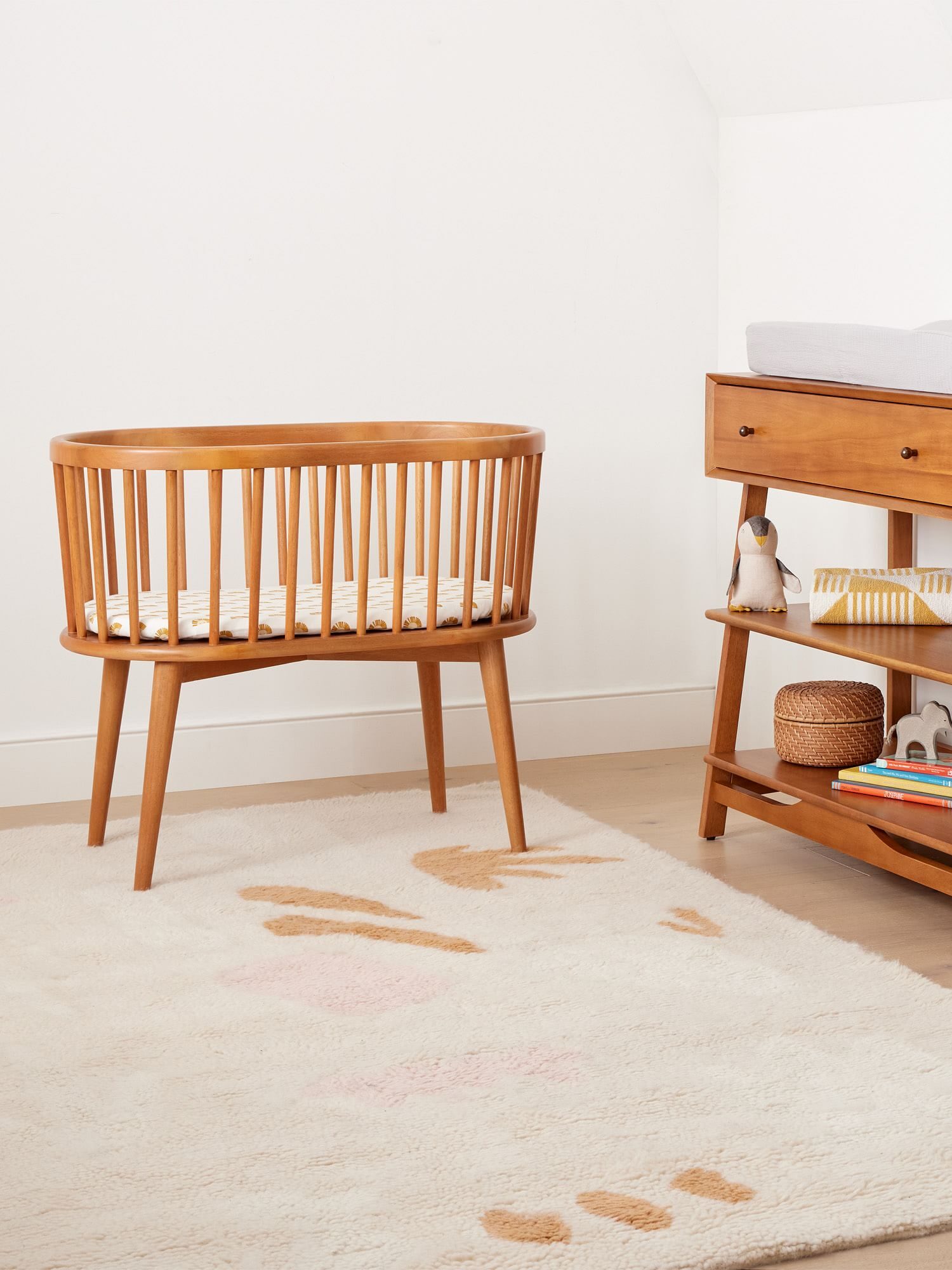 A warm wood bassinet in a bedroom
