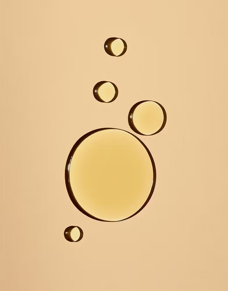 Several drops of oil on a yellow background.