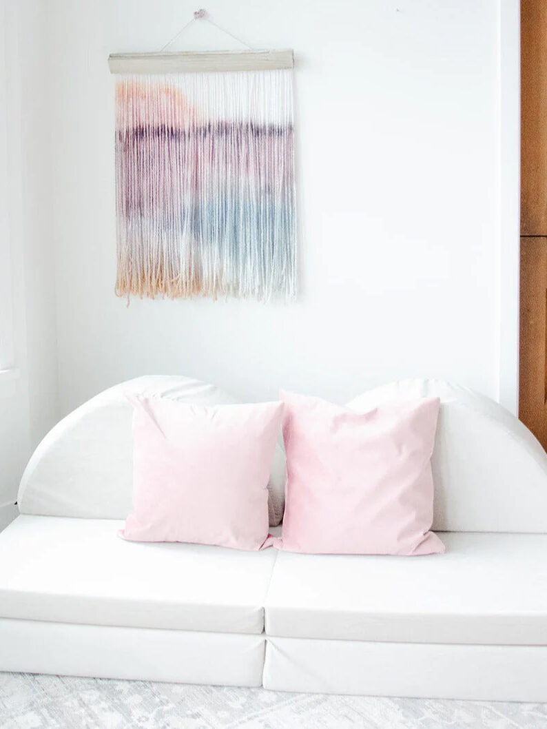 A white play couch with two pink cushions