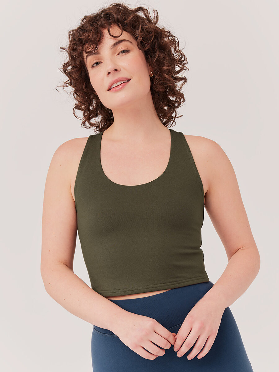 Model in green sports bra and blue leggings
