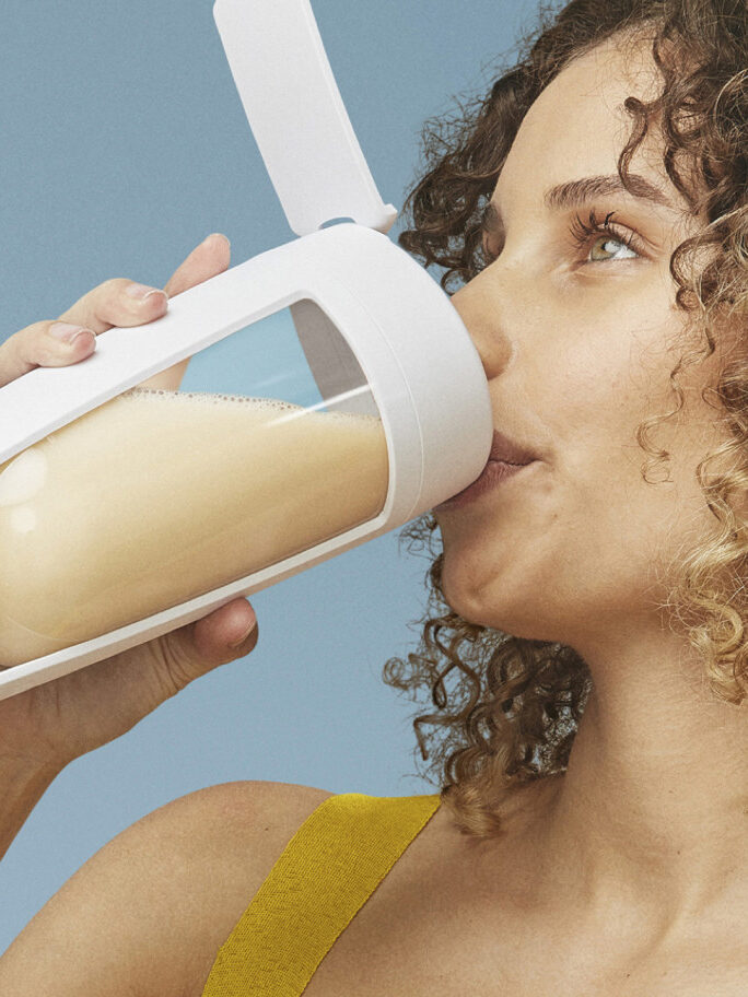 A model drinks a smoothie.