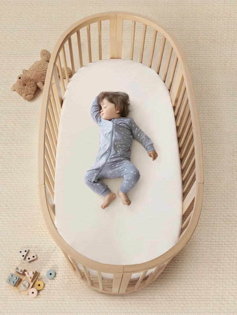 Looking down on a baby sleeping in an oval crib