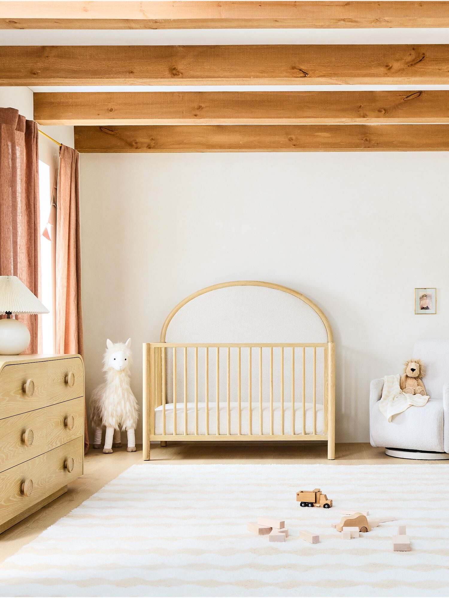 A natural wood crib in a bedroom