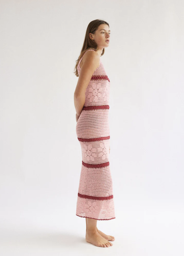 A model in a pink and red crochet dress