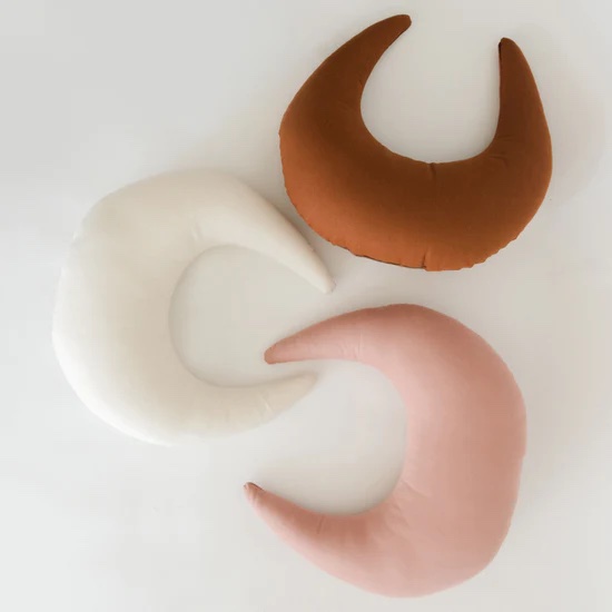 Three support pillows in cream, pink, and brown. 