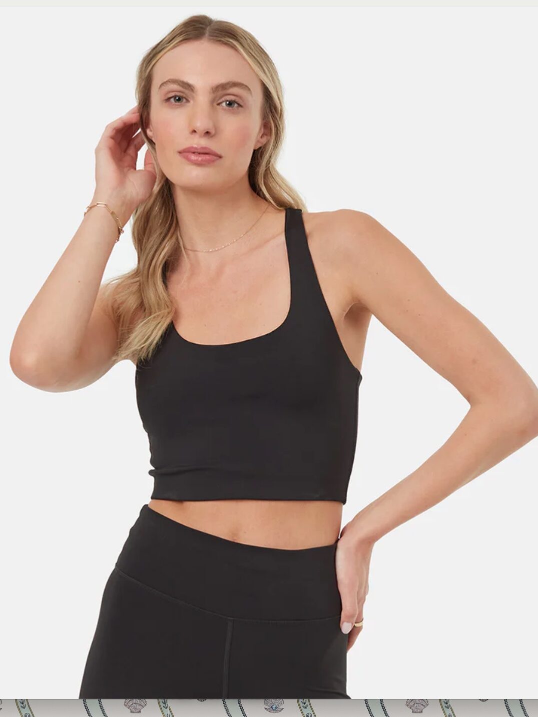 Model in matching black sports bra and leggings
