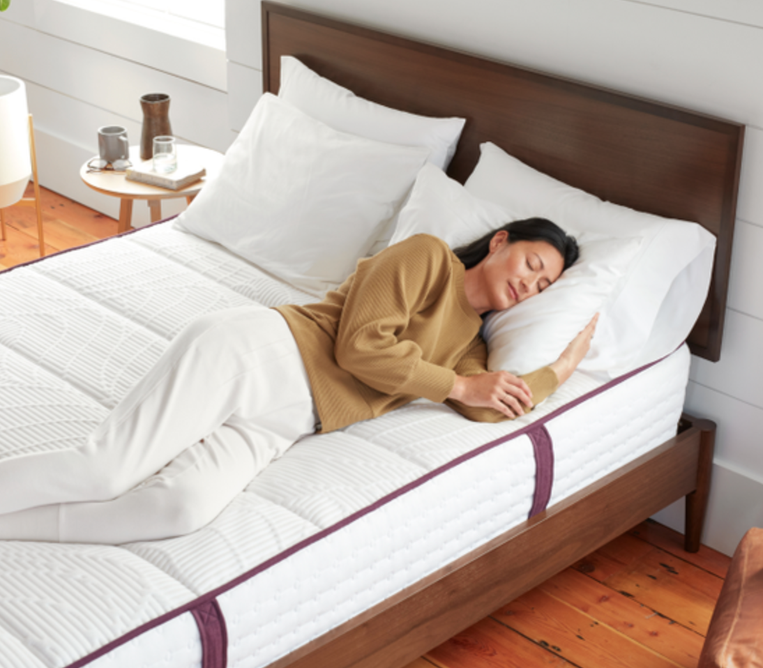 A person lies on a mattress and pillow.