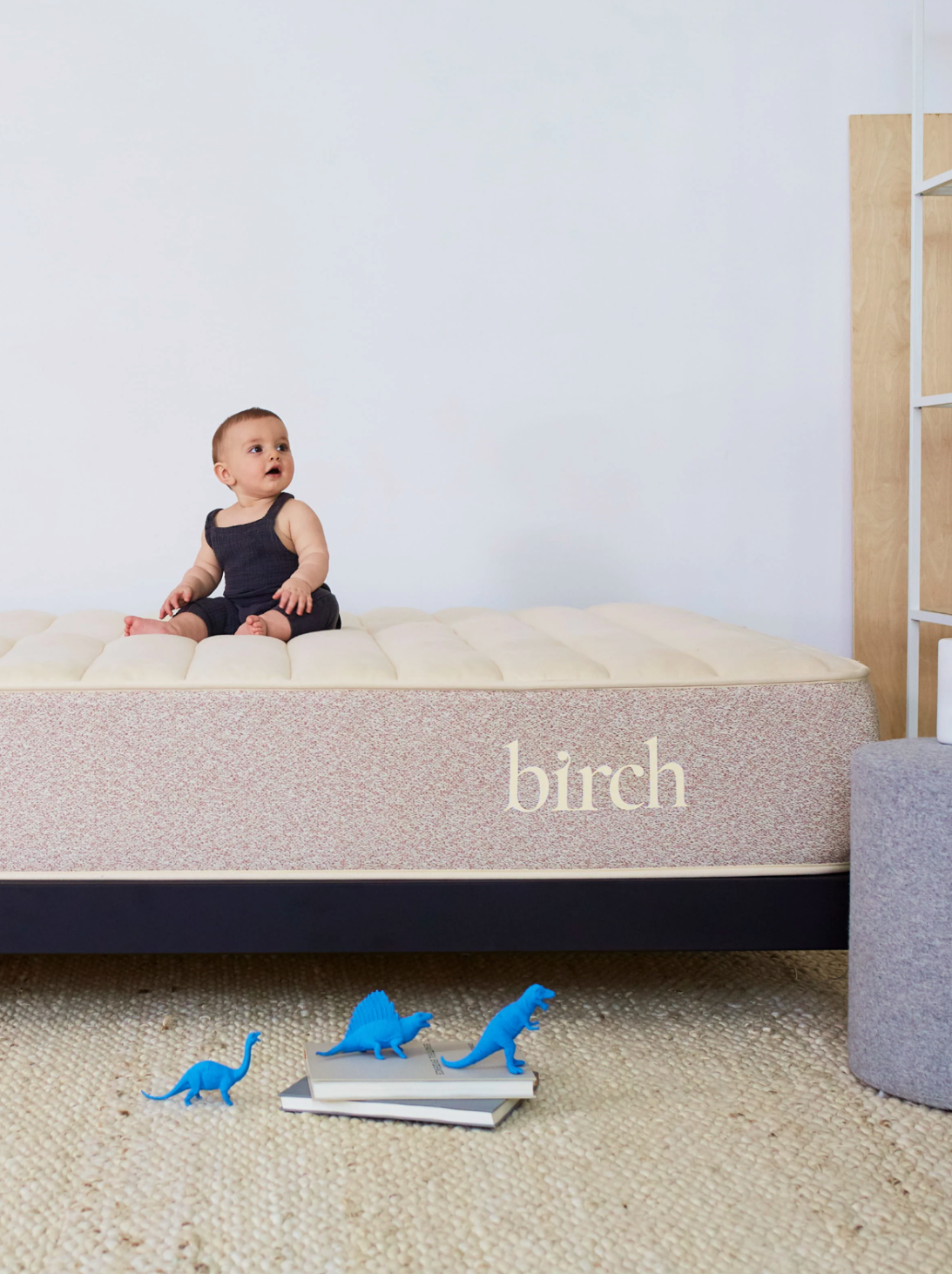A baby sits on a Birch mattress. 