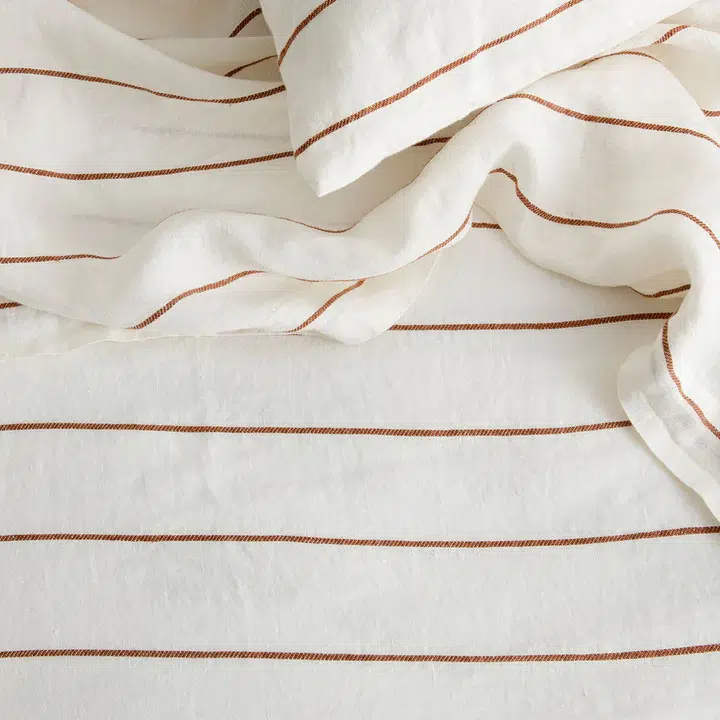 A cream and burnt sienna striped linen sheet set. 