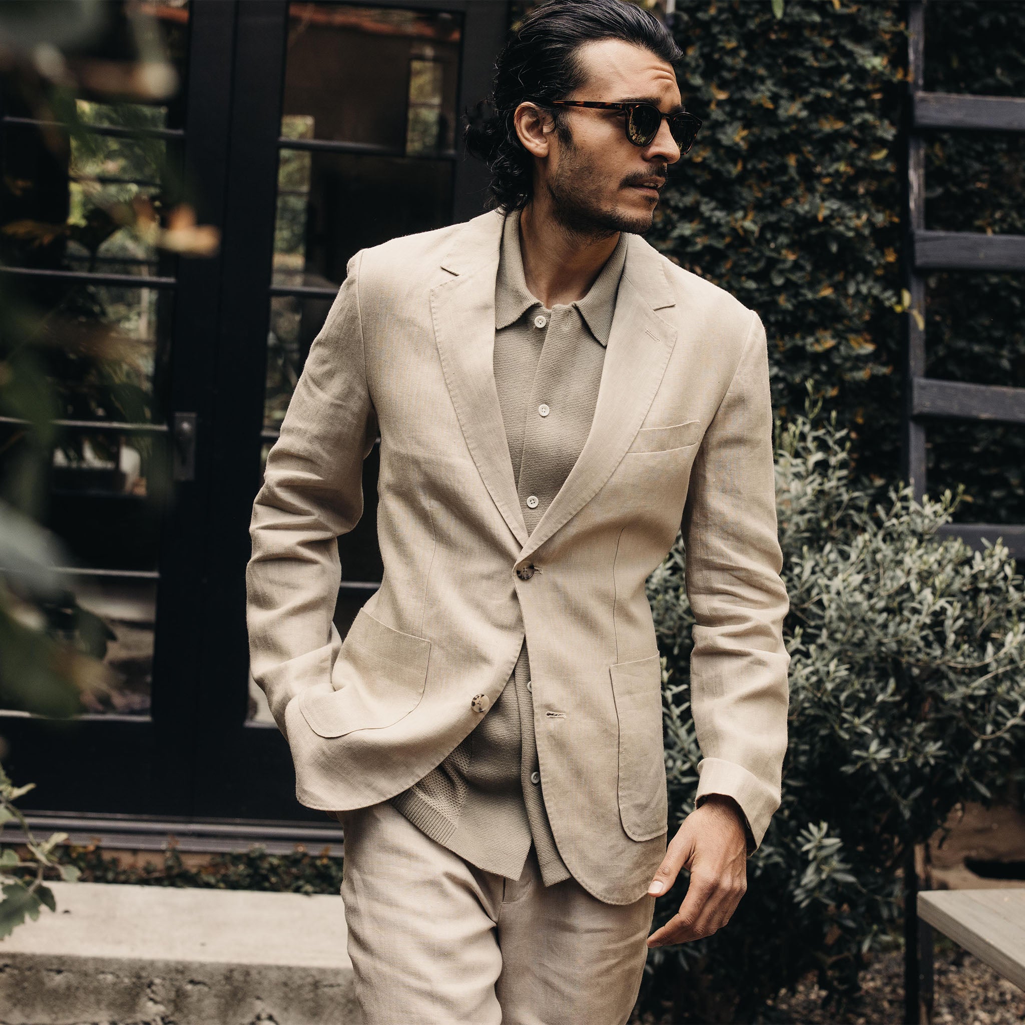 Model in a tan suit and sunglasses. 