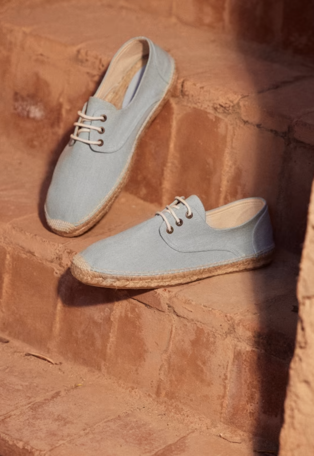 Blue espadrilles on brick stairs. 