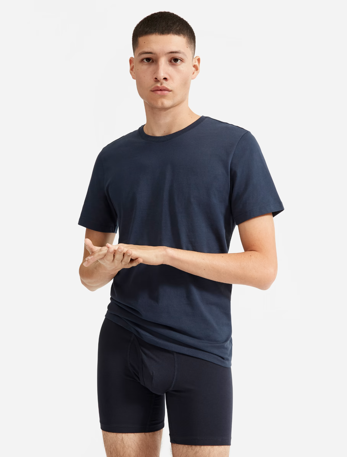 A model in a navy tee and dark boxer briefs.