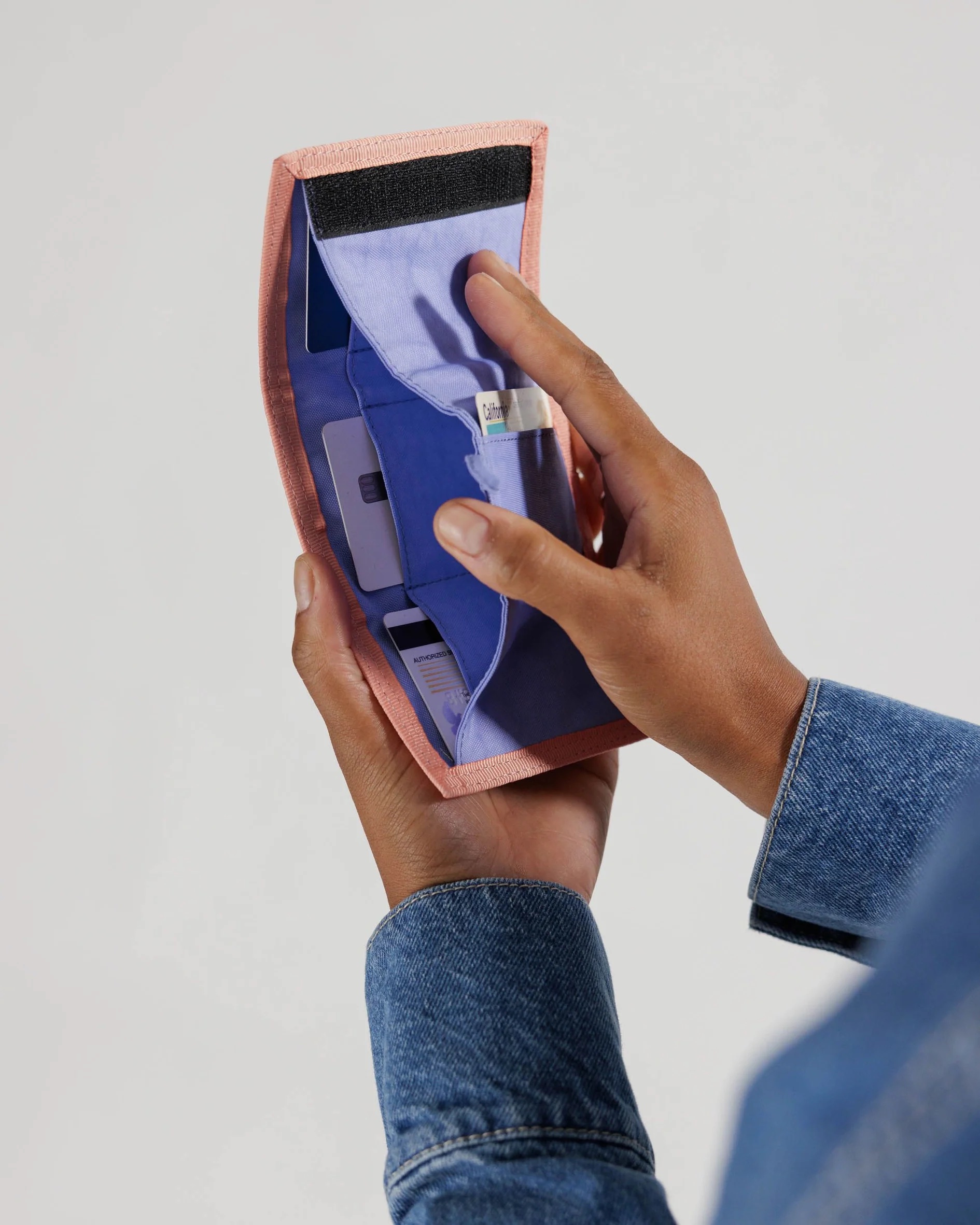 A close up of hands opening a wallet. 