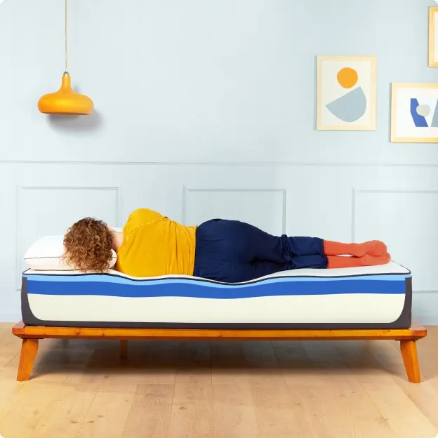 A model lies on her side to show the way the eco-friendly foam mattress conforms to her body. 