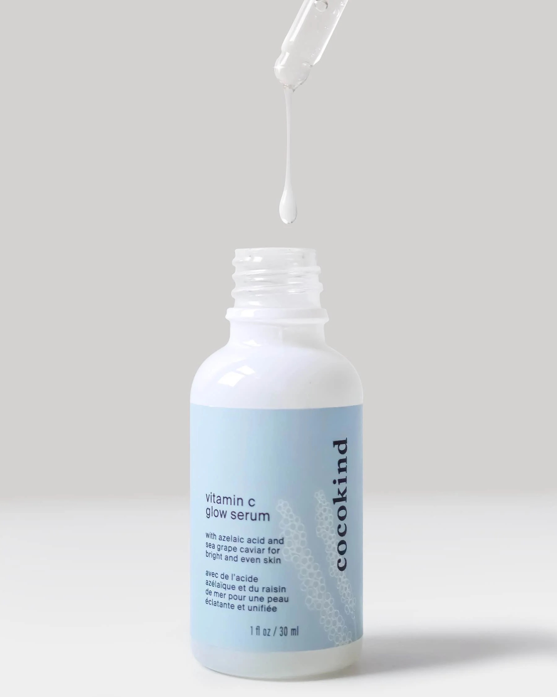 A dropper of serum falls into the product's bottle.