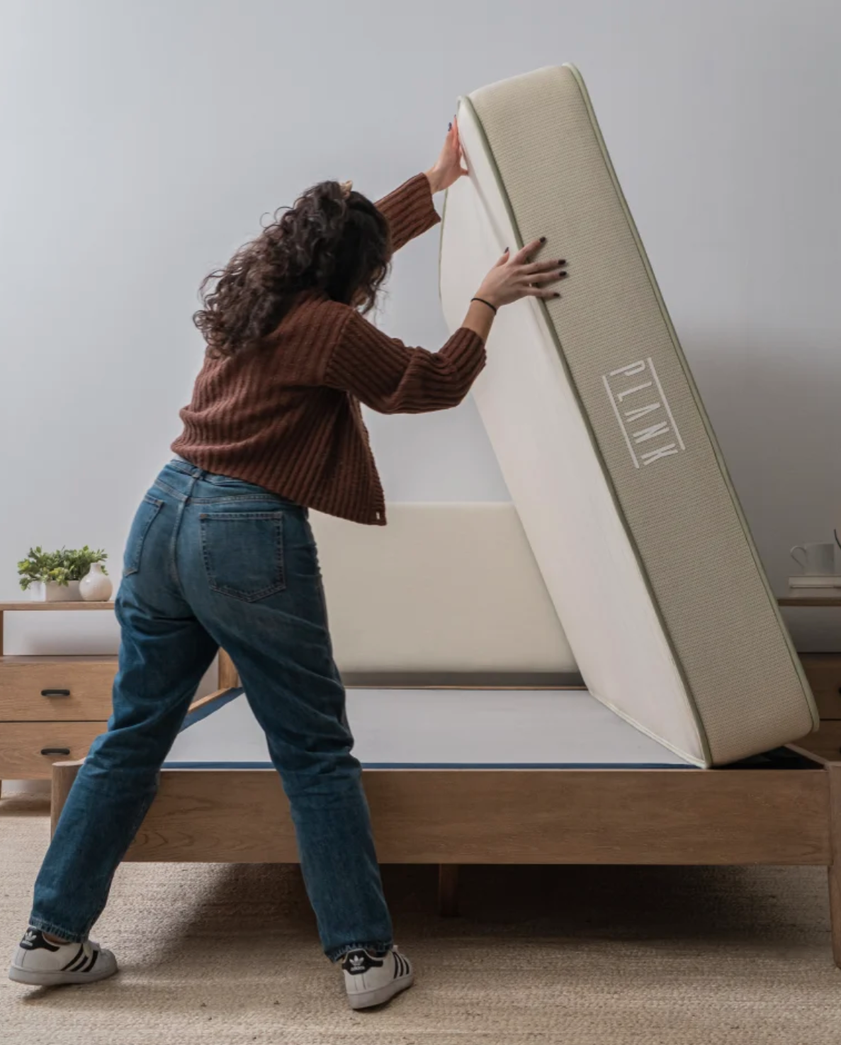 A woman flips a Plank mattress. 