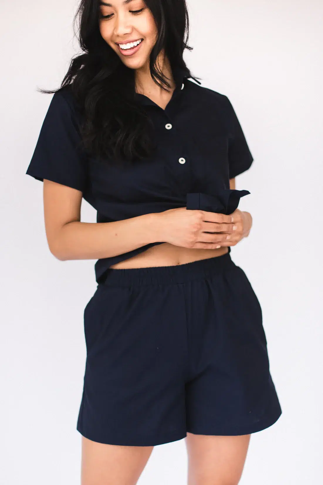 model in black linen matching set with short sleeve button down and elastic waistband shorts