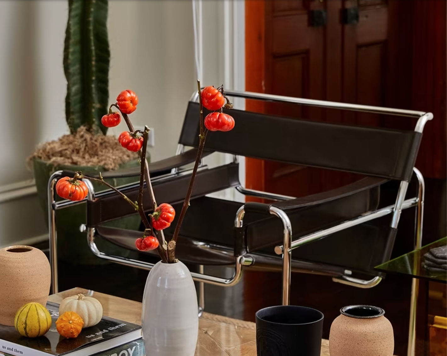 A metal and leather chair next to a styled coffee table. 