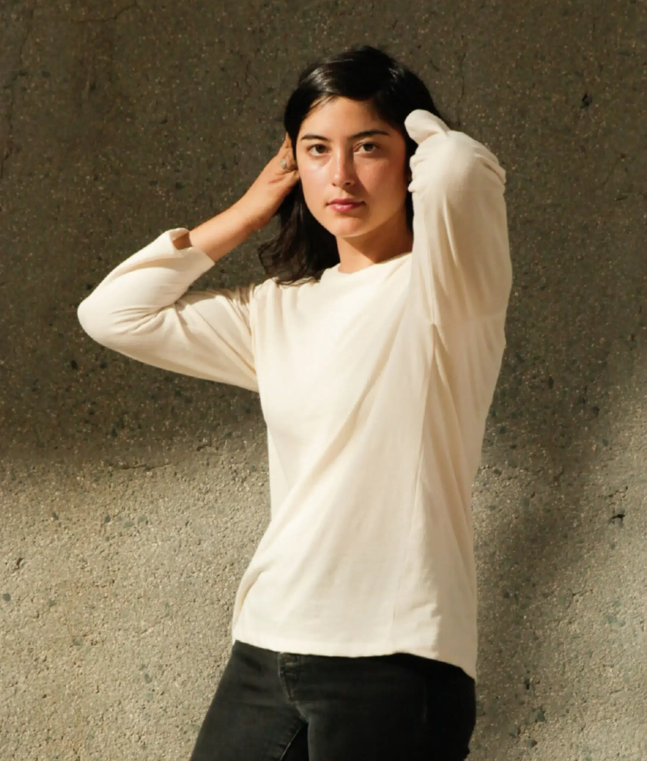 A model in a cream long sleeve shirt and black denim. 