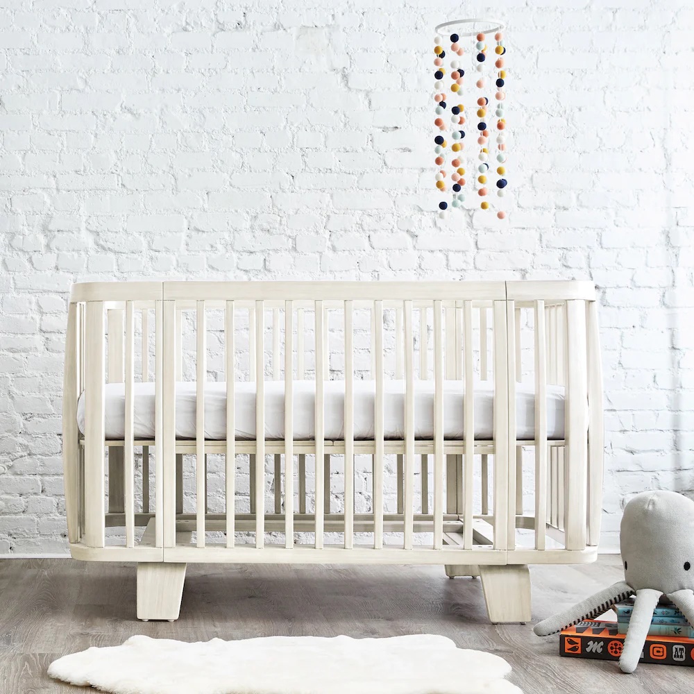 A white washed wooden crib.
