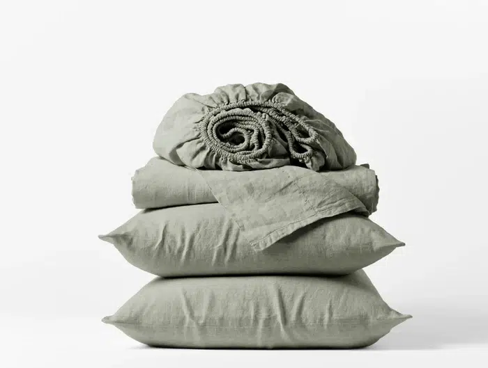 A stack of sage-colored linen sheets. 