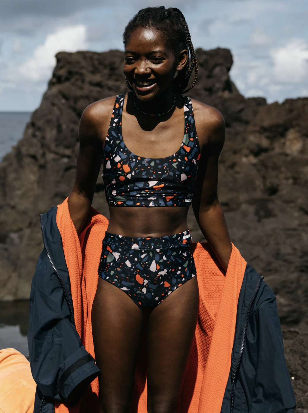 A model in a terrazzo print long line bikini with high waisted bottoms.