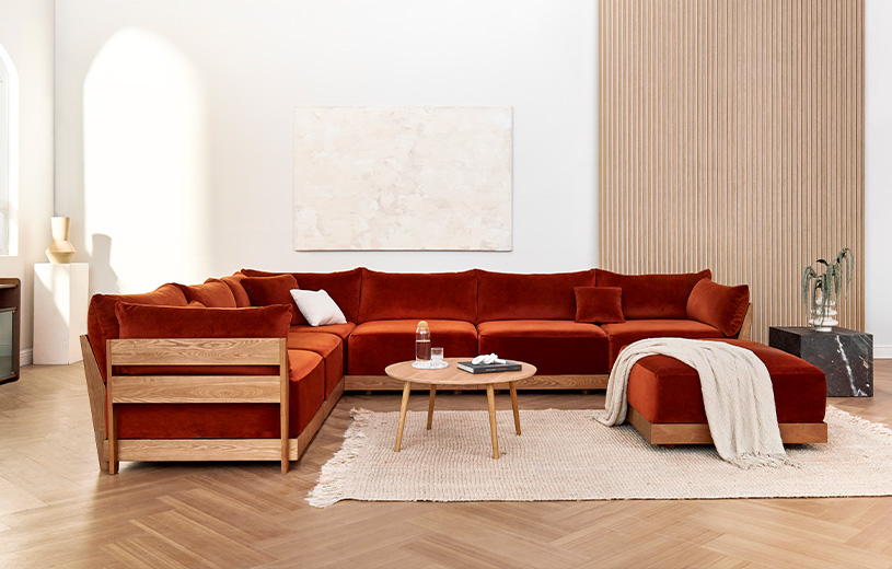 A burnt orange Inside Weather sectional in a living room.